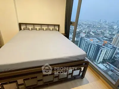 Modern bedroom with stunning city view from floor-to-ceiling windows in high-rise apartment.