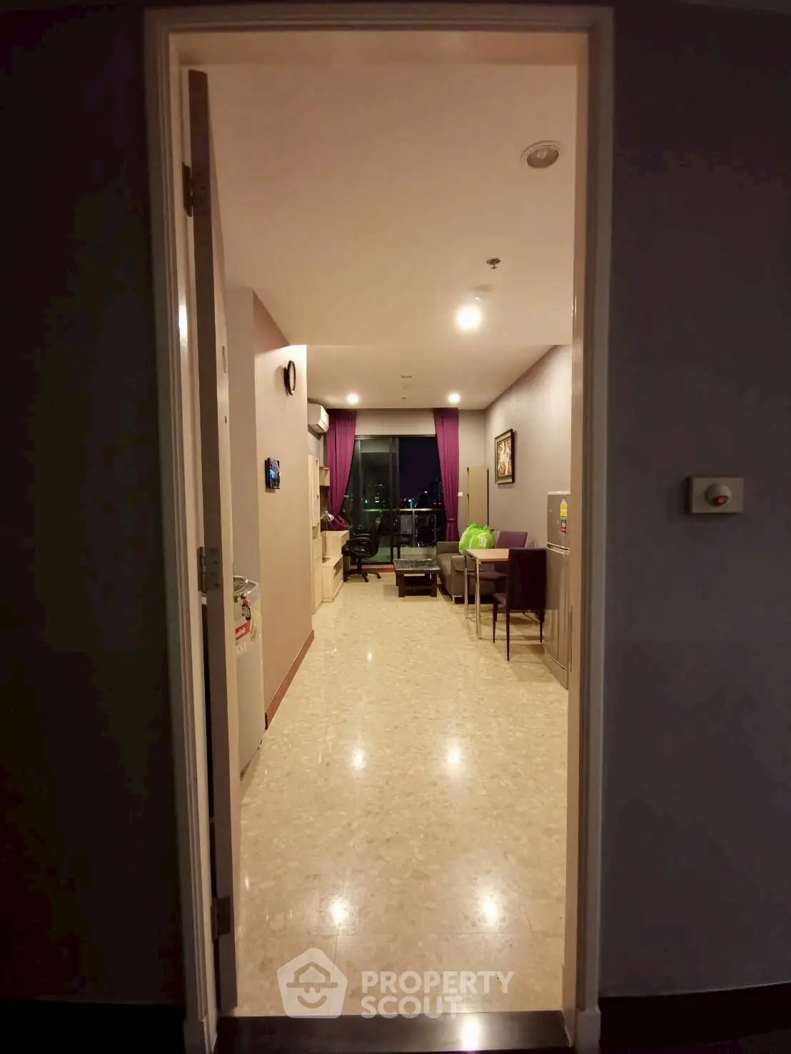 Spacious apartment entrance leading to a cozy living area with modern decor and city view.