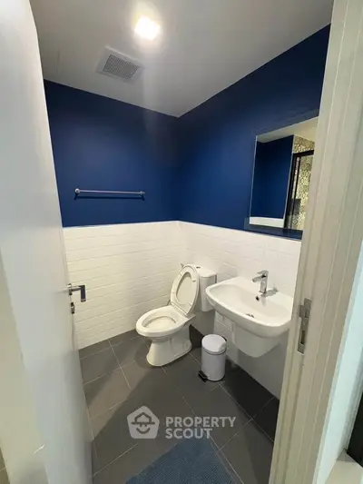 Modern bathroom with blue accent wall and sleek fixtures