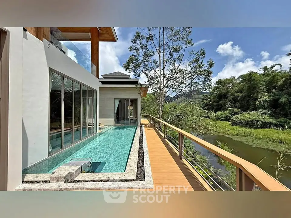 Luxurious modern home with stunning pool and scenic nature view.