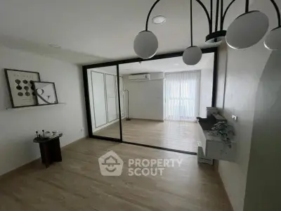 Spacious modern living room with elegant lighting and large mirror wall