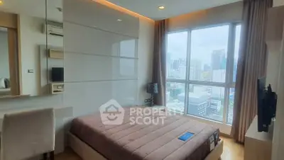 Modern bedroom with city view, featuring large window and stylish decor.