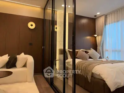Luxurious modern bedroom with glass partition and cozy seating area