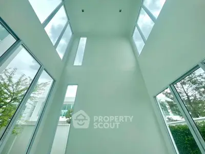 Stunning modern home with high ceilings and expansive windows offering abundant natural light.