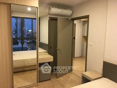 Modern bedroom with city view, featuring mirrored wardrobe and air conditioning.
