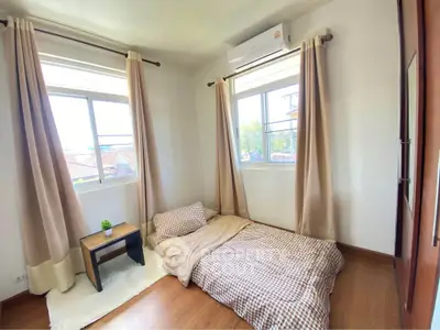 Cozy bedroom with natural light and minimalist decor, featuring a floor mattress and air conditioning.