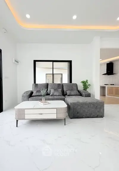 Modern living room with sleek gray sofa and elegant white coffee table on polished marble floor.
