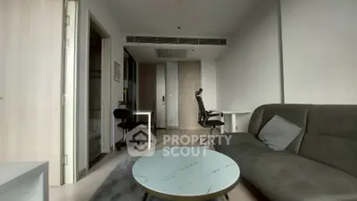 Modern living room with sleek furniture and workspace, ideal for urban living.