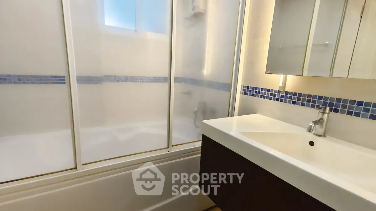 Modern bathroom with sleek vanity and glass shower enclosure
