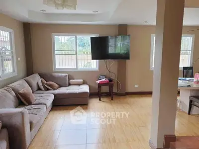 Spacious living room with large windows and modern decor, perfect for family gatherings.