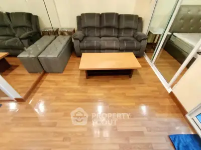 Cozy living room with plush sofa and wooden flooring, perfect for relaxation.