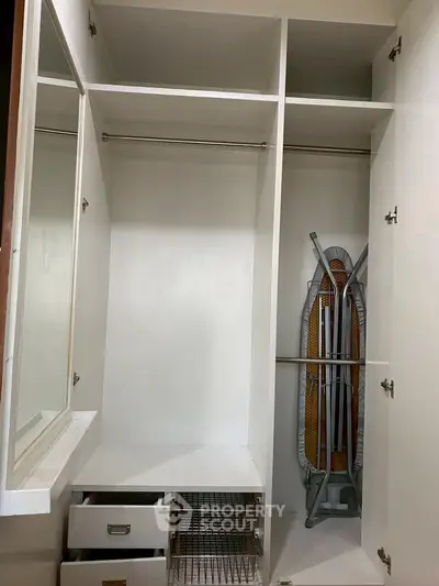 Spacious walk-in closet with built-in storage and ironing board
