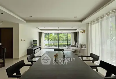 Spacious modern living room with large windows and garden view, perfect for family gatherings.