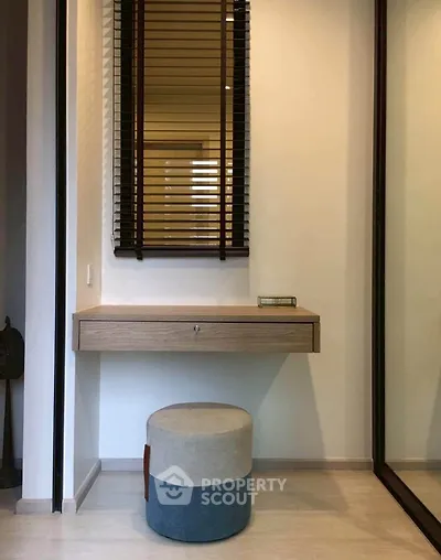 Modern minimalist study nook with floating desk and stylish stool in a contemporary apartment.
