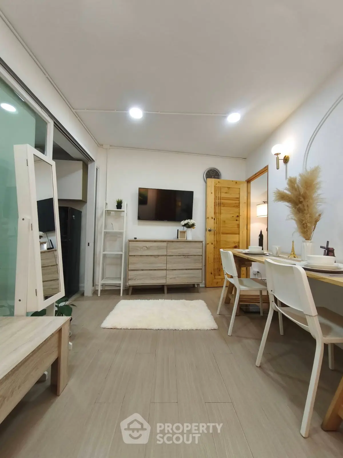 Modern living room with stylish decor and open layout, featuring a cozy dining area and sleek furniture.