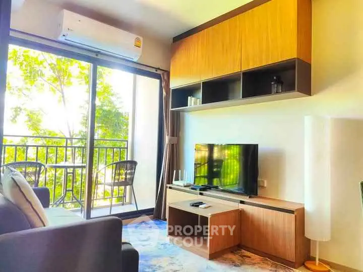 Modern living room with balcony view, stylish furniture, and natural light.