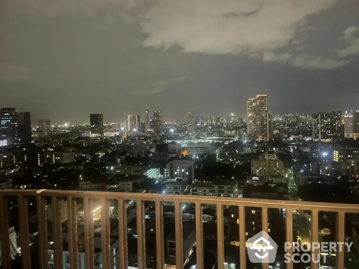 Stunning city skyline view from a high-rise balcony at night, showcasing urban lights and architecture.