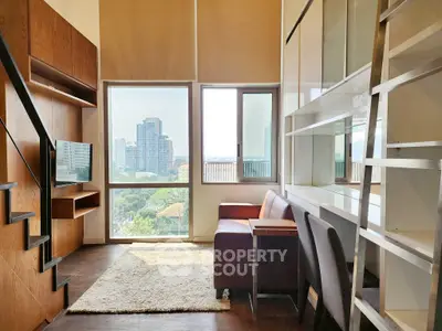 Modern loft-style living room with large windows and city view, featuring sleek furniture and a cozy atmosphere.