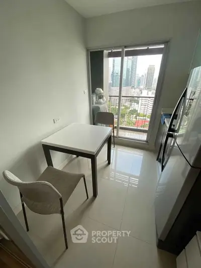 Modern kitchen with city view, sleek appliances, and cozy dining area in urban apartment.