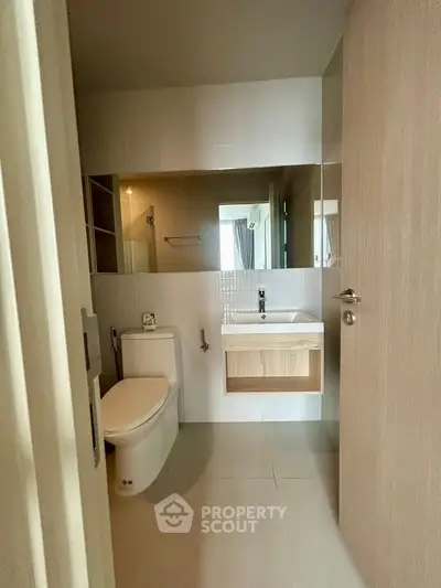 Modern bathroom with sleek fixtures and large mirror in a contemporary apartment.