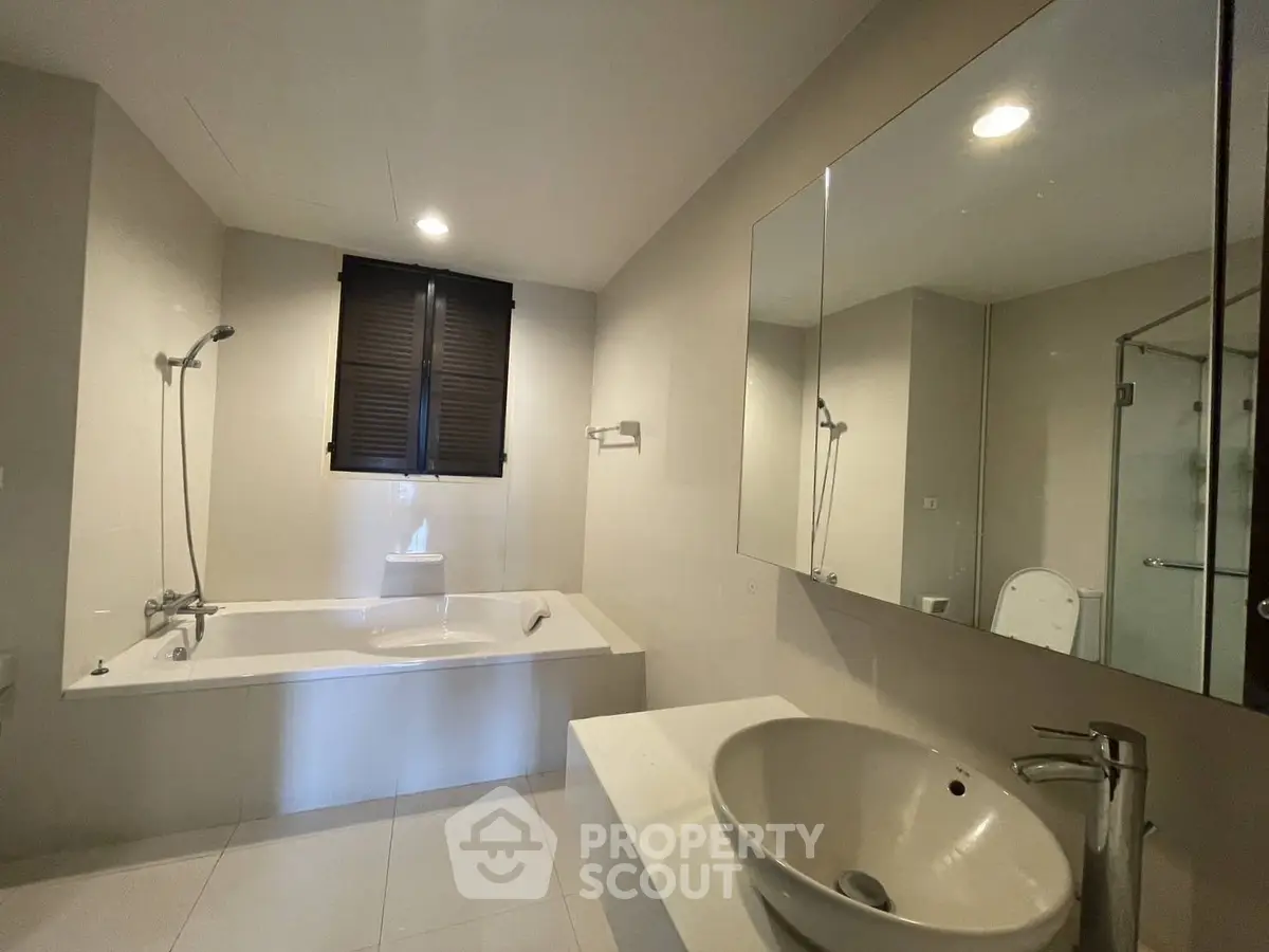 Modern bathroom with sleek fixtures and a spacious bathtub, perfect for relaxation and comfort.