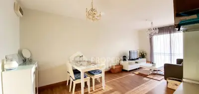 Spacious living room with elegant chandelier and natural light, perfect for modern living.