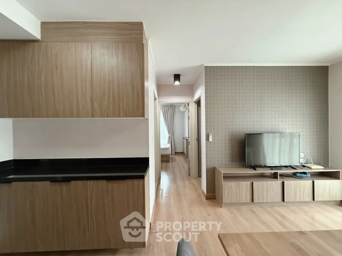 Modern living room with sleek wooden furniture and flat-screen TV