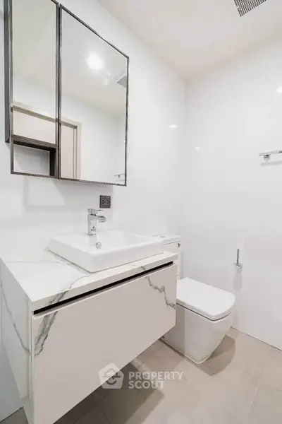 Modern minimalist bathroom with sleek fixtures and elegant marble vanity.