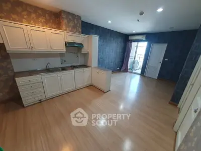 Spacious kitchen with open layout and balcony access in modern apartment.
