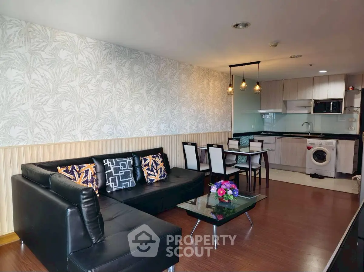 Modern living room with stylish decor, open kitchen, and cozy seating area in a contemporary apartment.