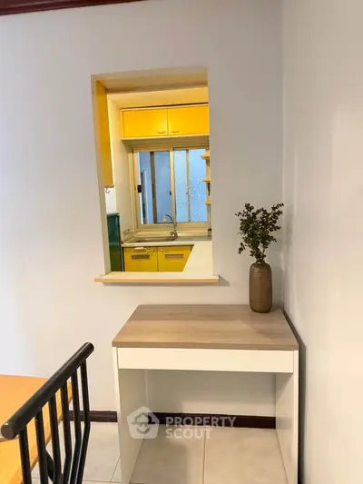 Charming kitchen with vibrant yellow cabinets and a cozy dining nook, perfect for modern living.