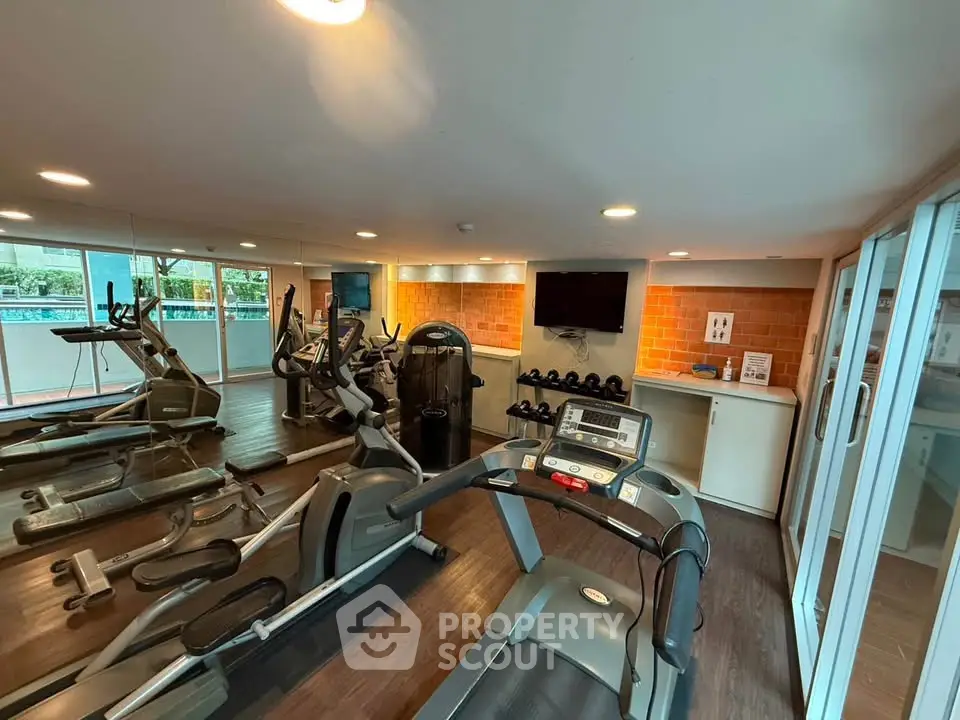 Modern gym with state-of-the-art equipment and mirrored walls in a residential building.
