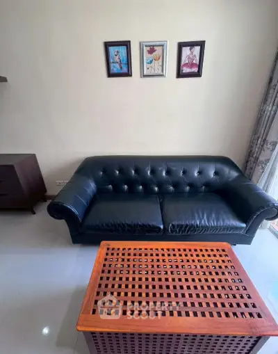 Stylish living room with elegant black leather sofa and wooden coffee table, perfect for modern interiors.
