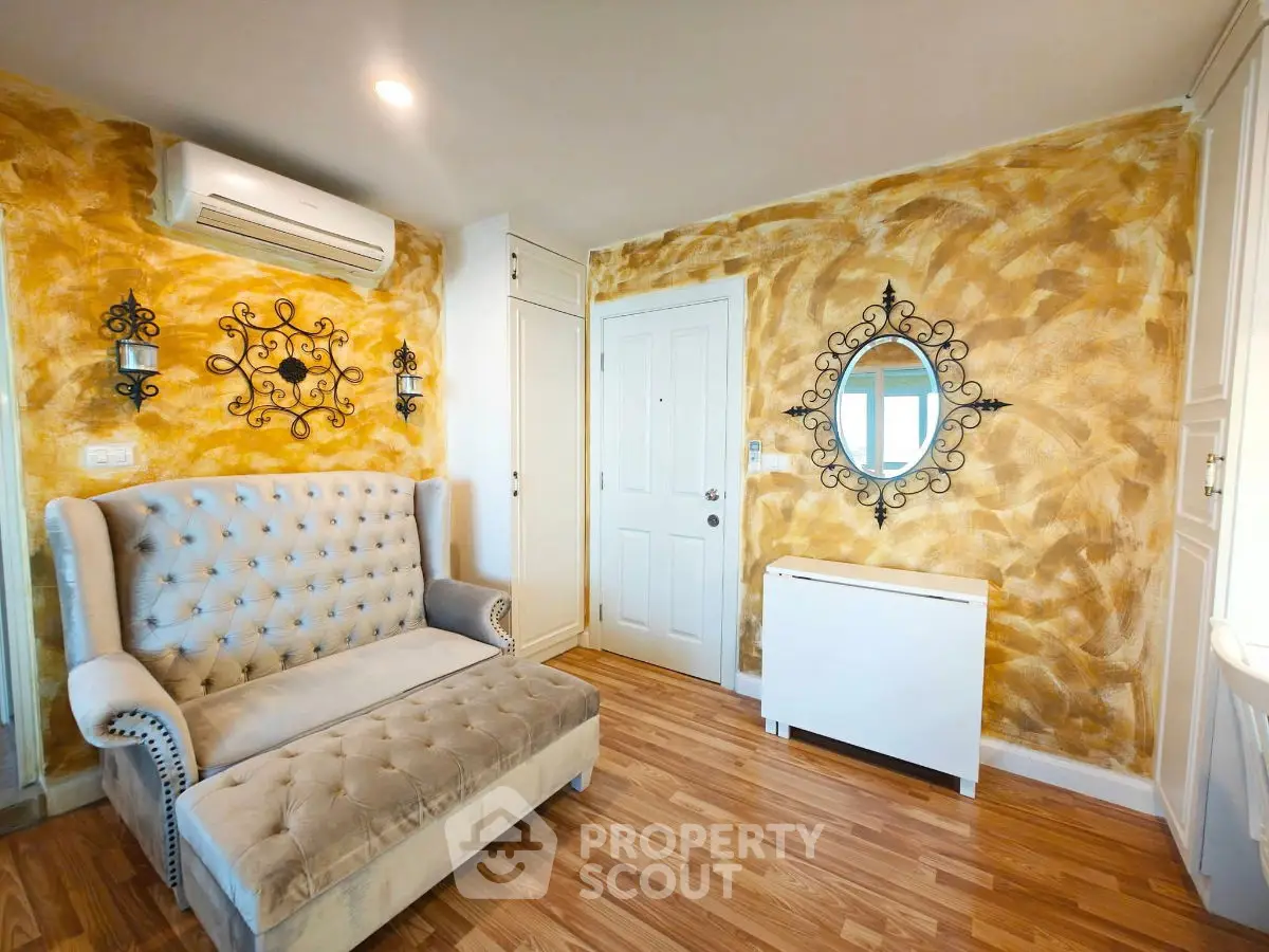 Charming living room with elegant sofa and artistic wall design, perfect for cozy relaxation.