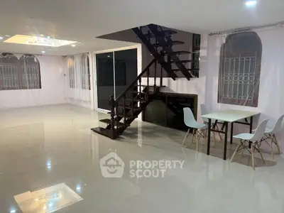 Spacious modern living room with elegant staircase and dining area