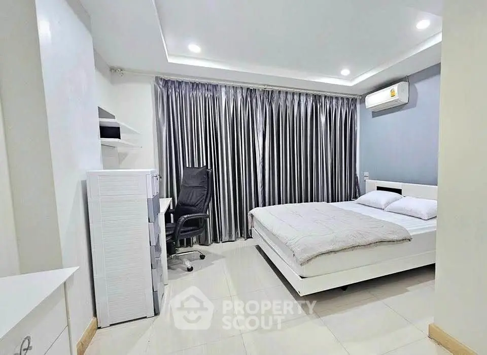 Modern bedroom with sleek design, featuring a comfortable bed, study desk, and elegant curtains.