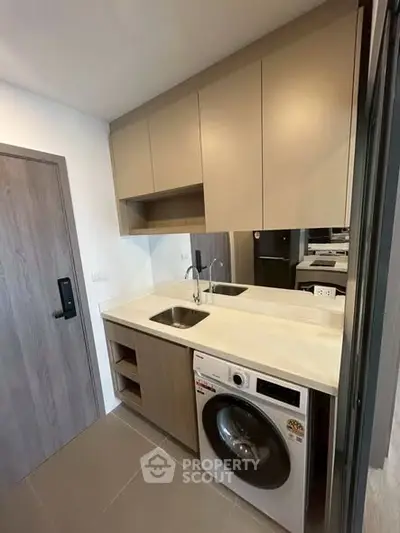Modern compact kitchen with washing machine and sleek cabinetry