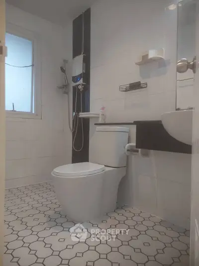 Modern bathroom with sleek fixtures and geometric tile flooring