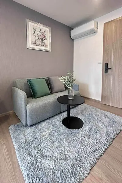 Modern living room with cozy sofa, stylish decor, and air conditioning unit.