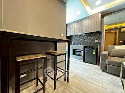 Modern open-layout kitchen with stylish bar stools and cozy living area.