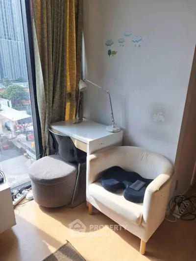 Cozy study nook with city view, featuring a desk, chair, and natural light through large window.