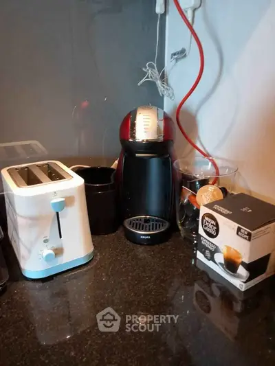 Modern kitchen corner with coffee machine and toaster on sleek countertop.