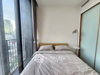 Modern bedroom with city view and balcony access in urban apartment