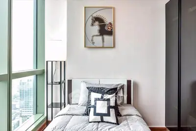 Modern bedroom with stylish decor and large window offering city views.