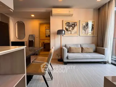 Modern living room with stylish decor and natural light, featuring a cozy sofa and elegant dining area.