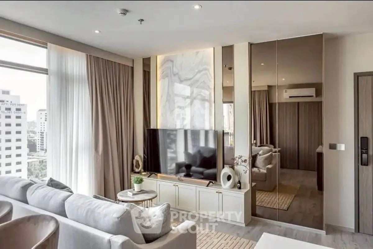 Luxurious modern living room with large windows and elegant decor in a high-rise apartment.