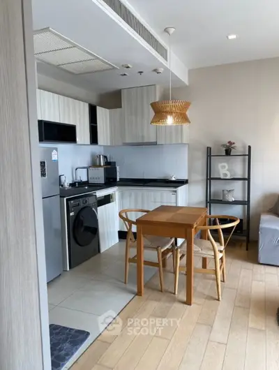 Modern kitchen with dining area, featuring sleek appliances and stylish decor in a cozy apartment setting.