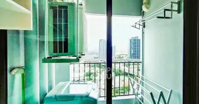 Compact laundry area with washing machine and city view from balcony