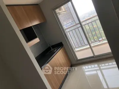 Modern kitchen with sleek cabinets and balcony view in high-rise apartment