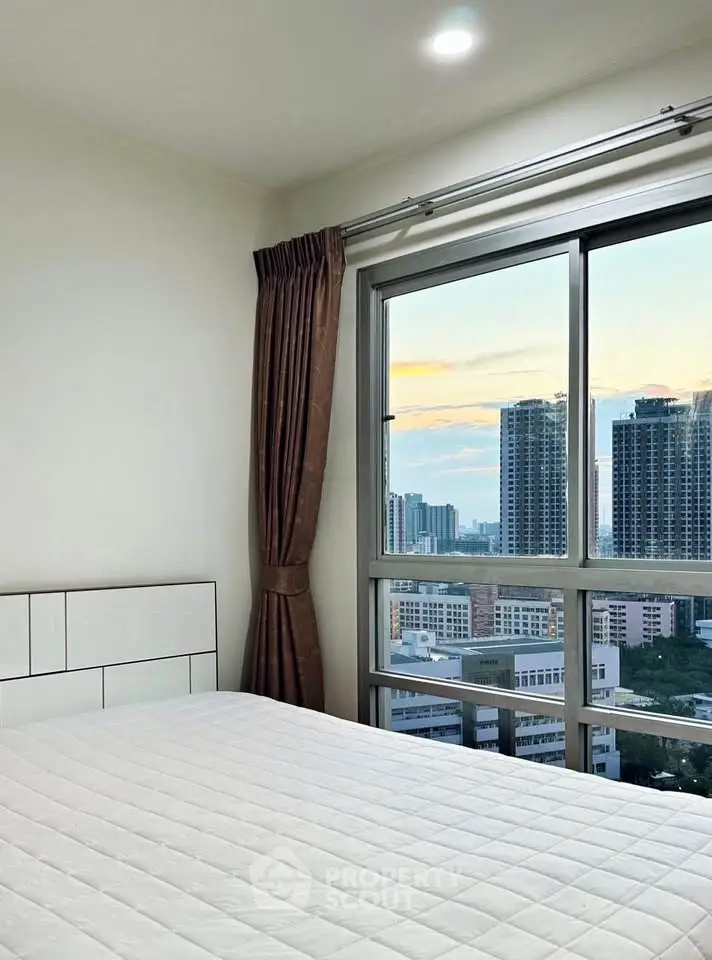 Modern bedroom with city view and large window in high-rise apartment